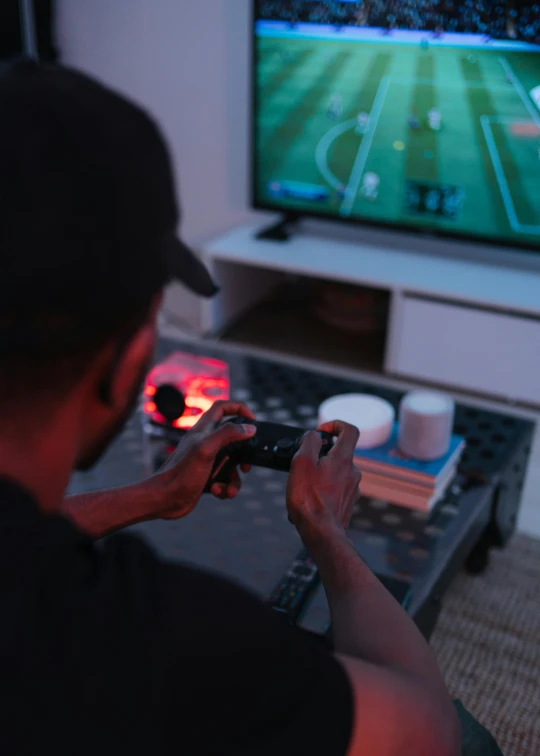 a man holding a remote in front of a flat screen tv