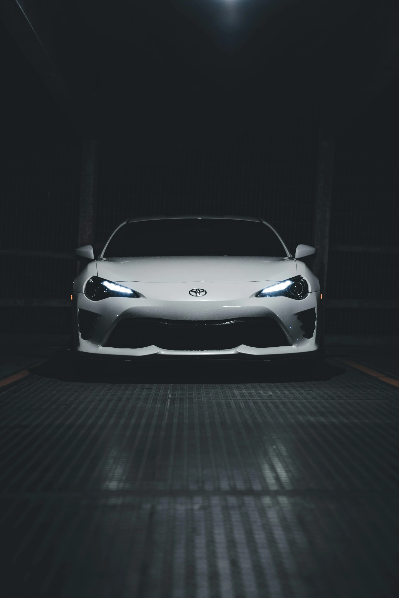 a white sports car in a dimly lit garage