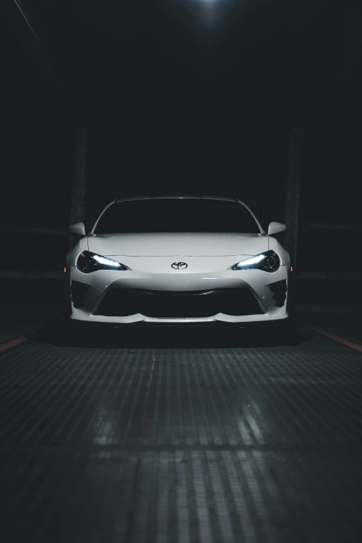 a white sports car in a dimly lit garage