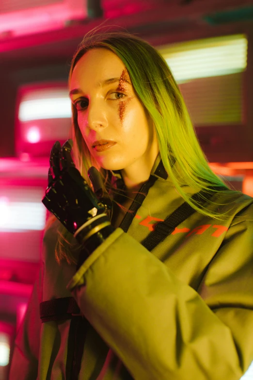 a woman in a green jacket and black gloves with black writing on her face