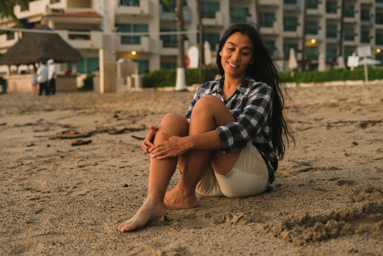 a person sitting on a beach and a building