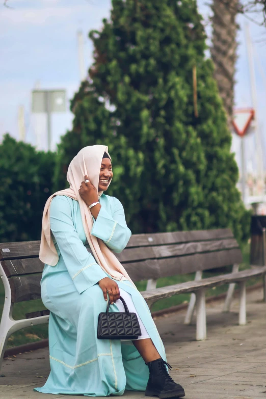 a woman sits on a bench talking on her phone