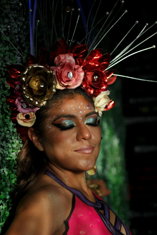 a woman with flowers on her head wearing makeup