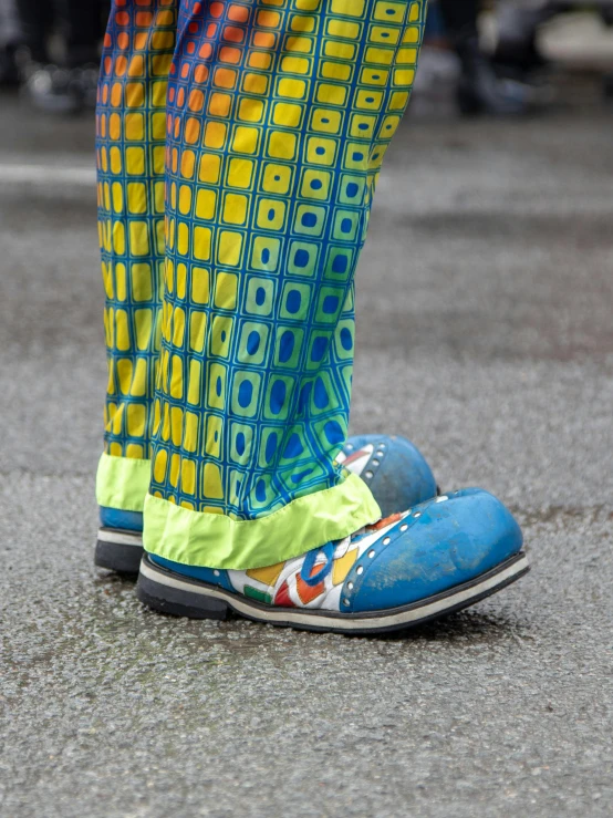 a close - up of the foot and shoes of an individual wearing colorful clothing