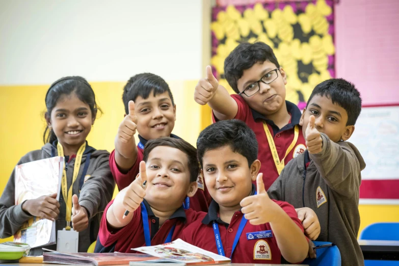 children are smiling for the camera and pointing their hands