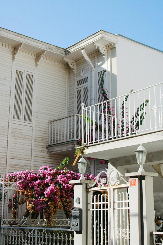 a tall white house with flowers on the outside of it