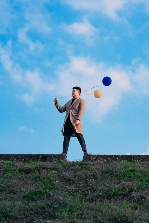 the man is flying a kite in a green grassy field