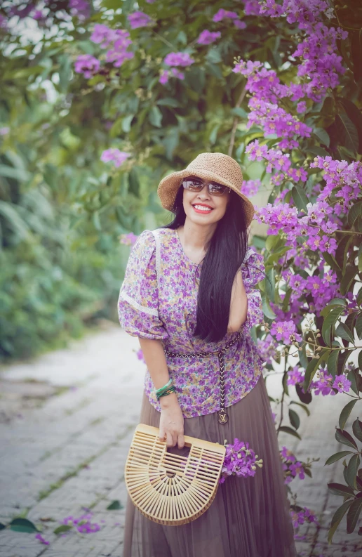 a woman is standing next to some purple flowers