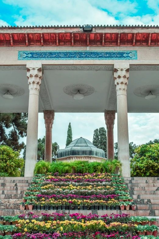 a colorful landscape with lots of flowers surrounding a gazebo