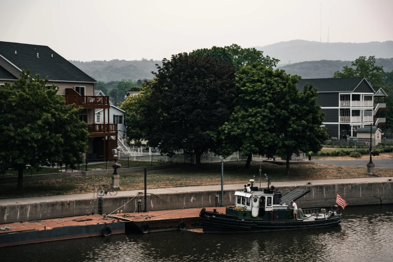 a small boat is at the dock with houses in the background