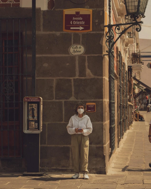 a man in white shirt standing next to a building