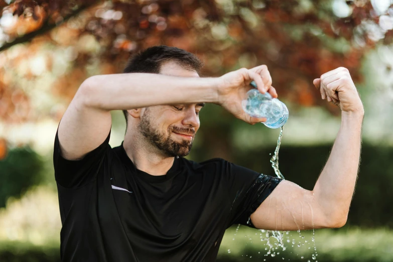 the man is drinking from a water bottle