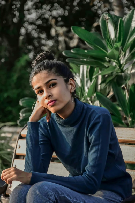 the woman sits on a park bench posing for a po