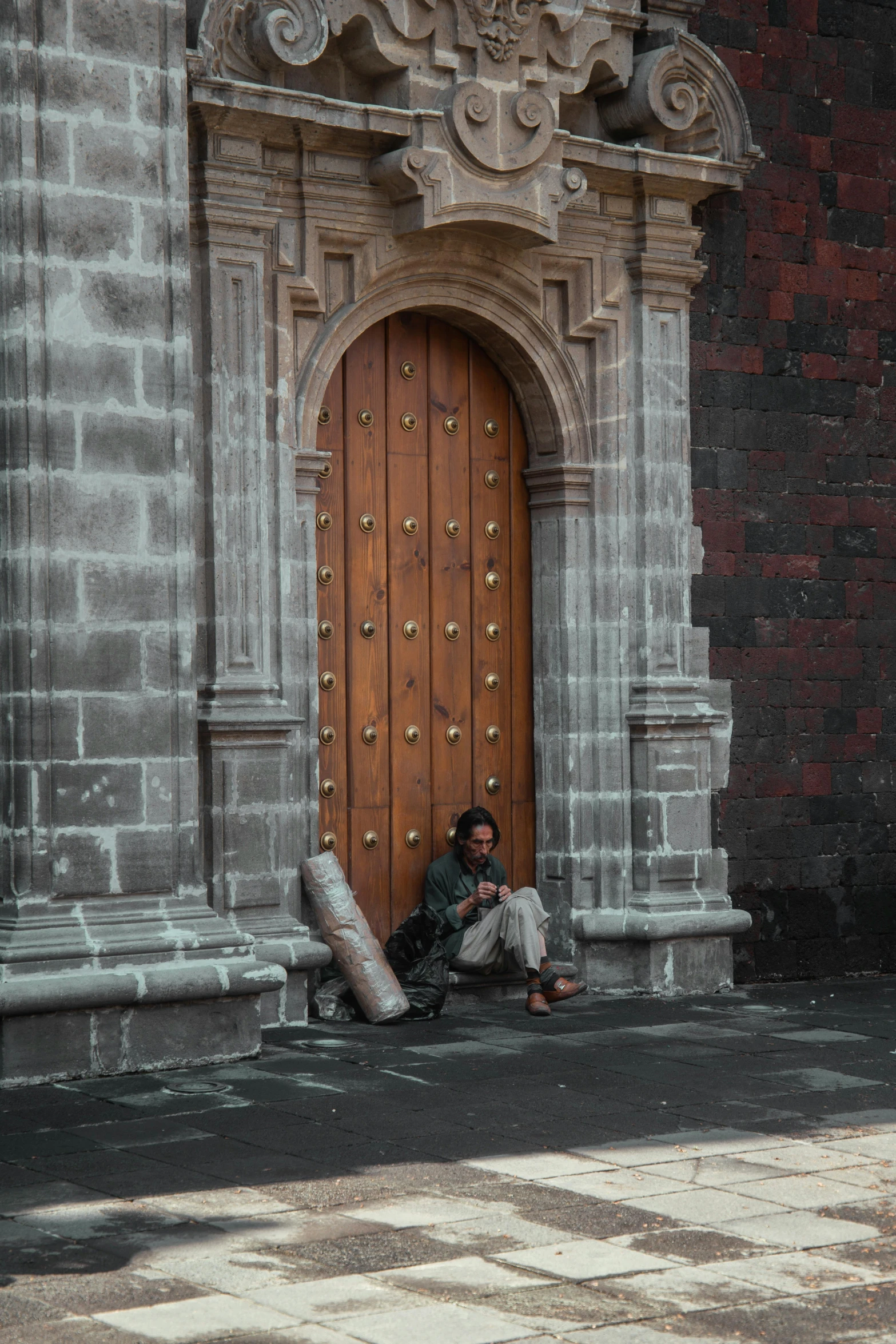 a man sitting on the ground in front of a door