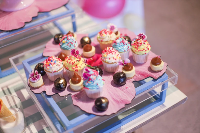 cupcakes displayed on serving platters with pink flowers