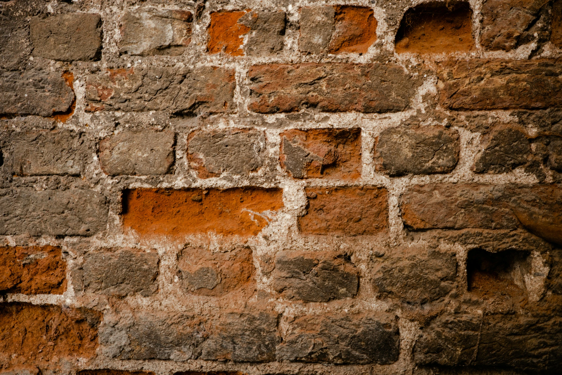 an orange brick wall with several holes cut in it