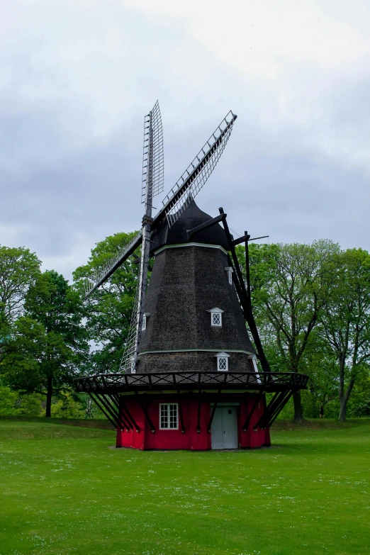 the large windmill has many people looking inside