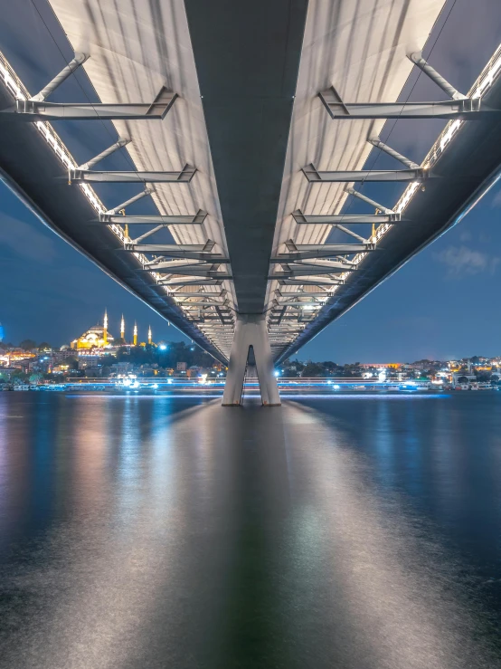 a large white bridge with a city across the water