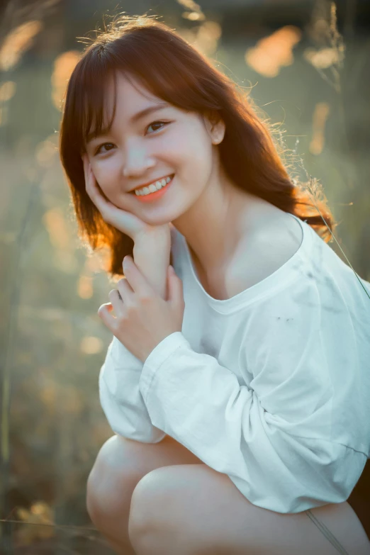 a young asian woman wearing a white top sitting on the ground