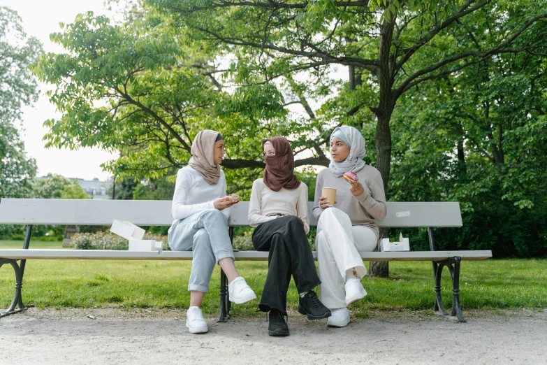 three women sitting on a bench next to each other