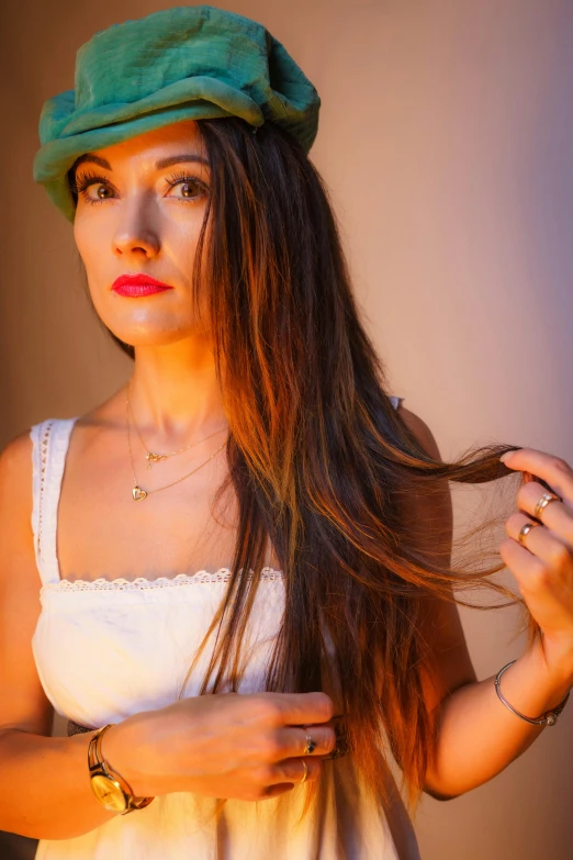 a woman wearing a hat while straightening her hair