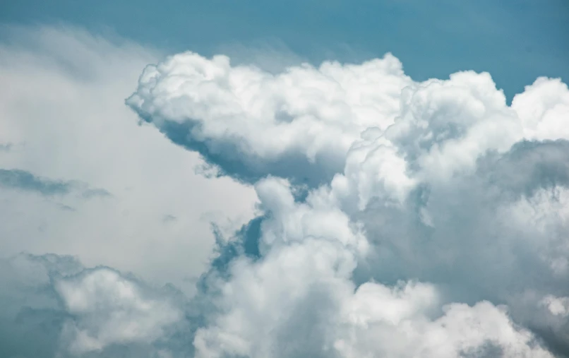 the airplane in the sky has clouds surrounding it