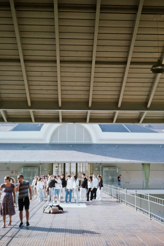 people standing around near a swimming pool at the end of a boardwalk