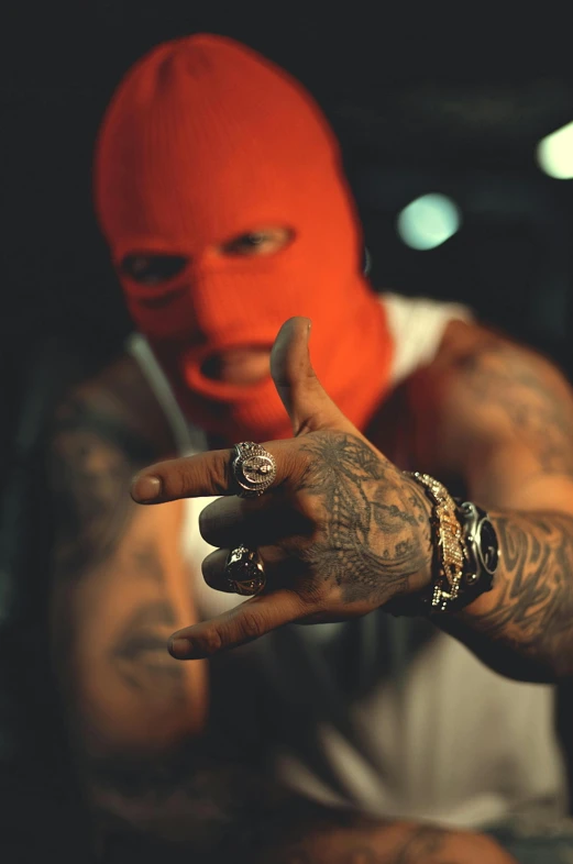 a young man in a red mask holding a peace sign