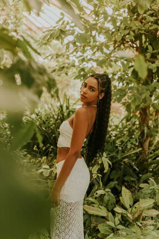 the young woman is posing for a pograph in a green house