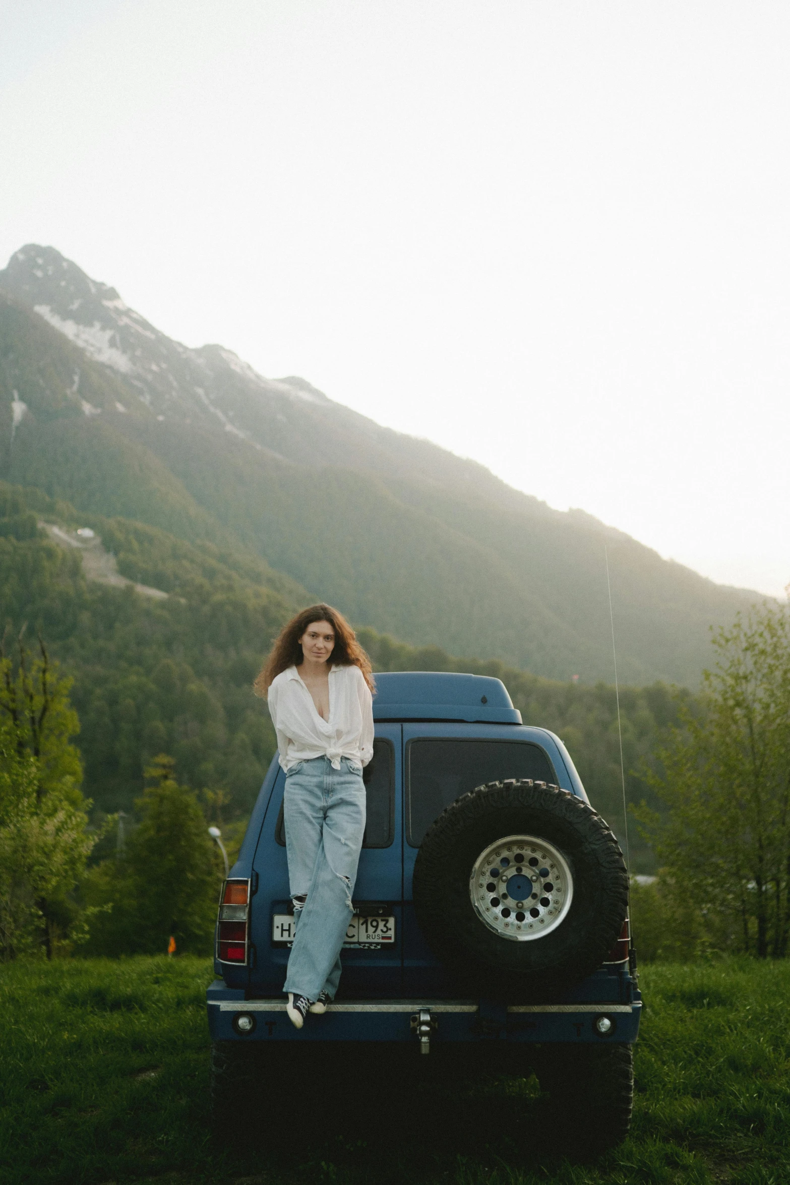 a  sitting on the back of a truck in front of mountains