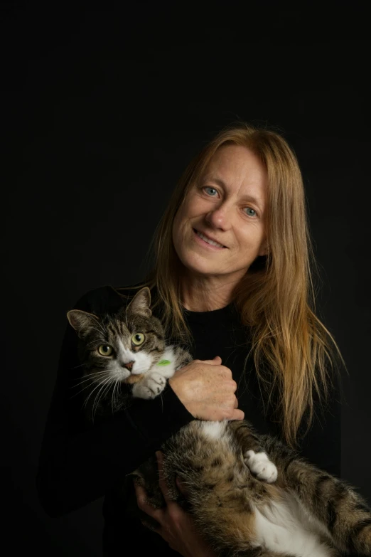 a woman holding a cat on her hands