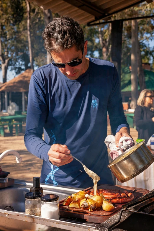 a man preparing food on top of an outdoor grill