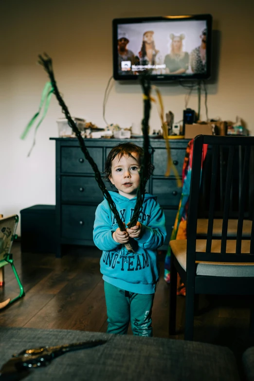 a small child is holding a rifle in a living room