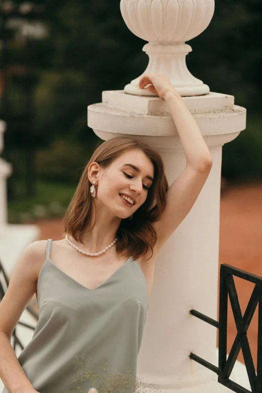 a young woman posing next to a stone fountain