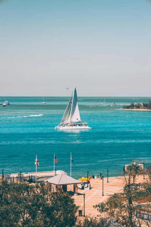 sail boat floating in the ocean near a dock