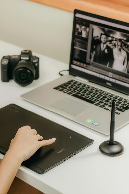 a woman is working on a laptop with a camera