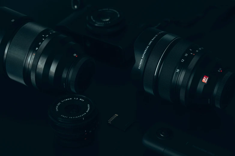 three different types of cameras sitting on a black surface