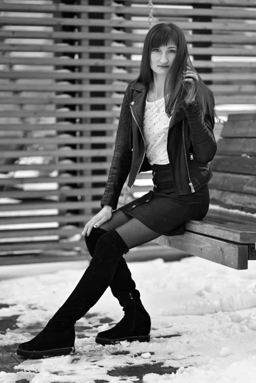 a woman sitting on a bench in the snow