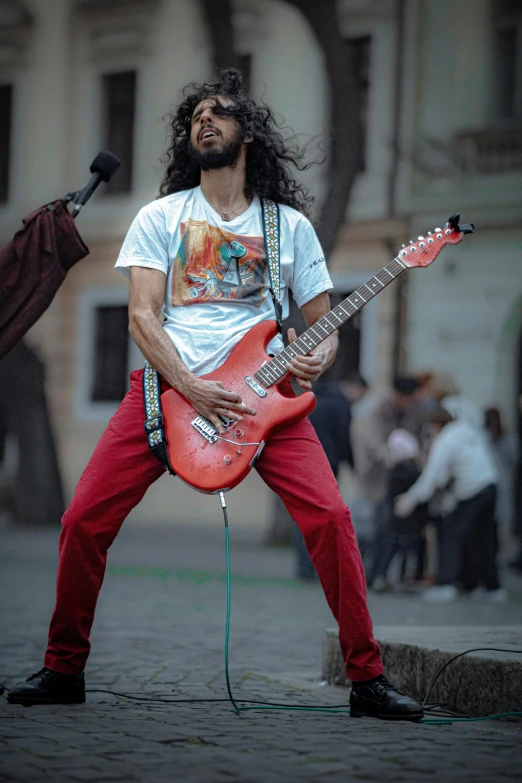 a man with long hair holding an electric guitar