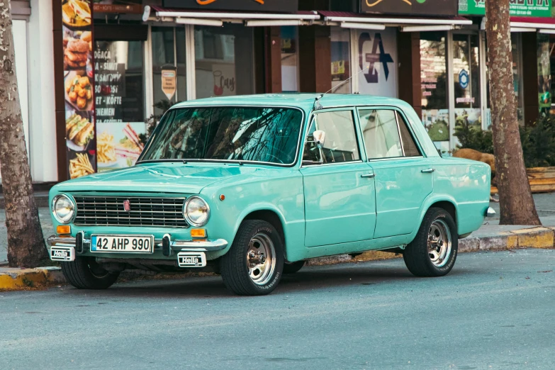 a light blue car parked on the side of a road