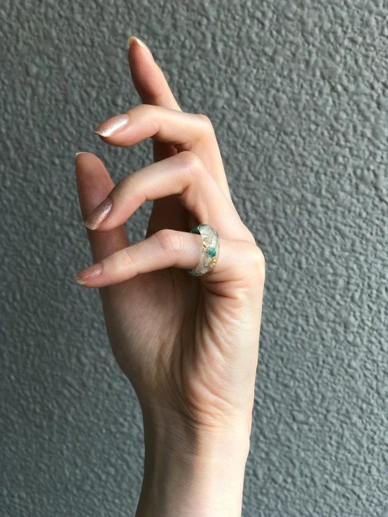 a woman holding onto her fingers in one hand with a ring on it