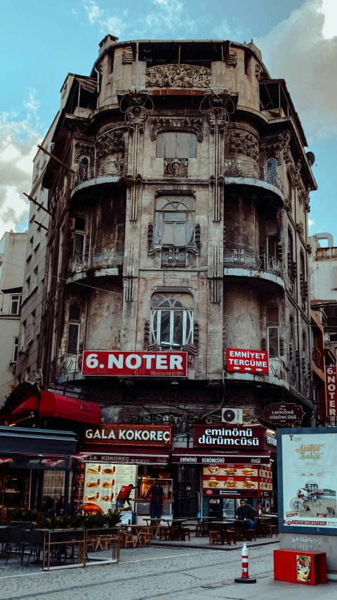 an old building sitting behind many shops on a busy street