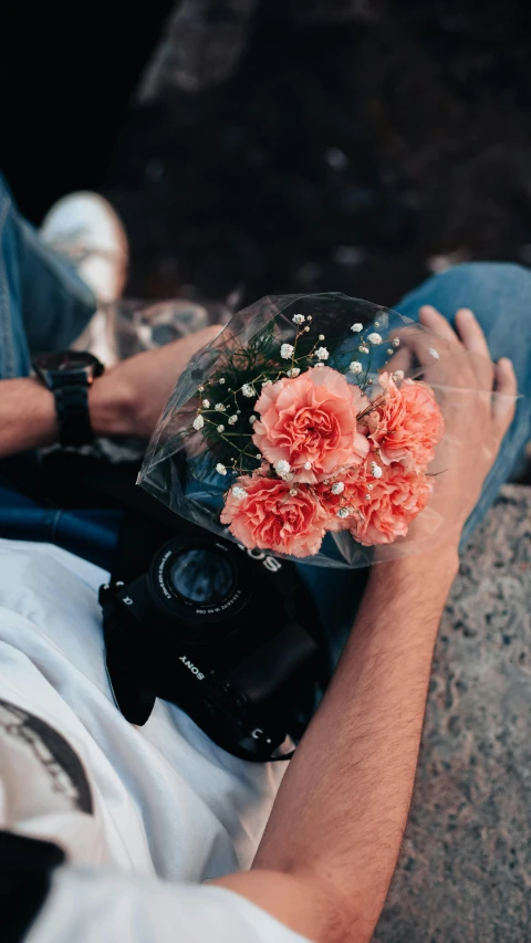 the person is sitting on the ground with flowers