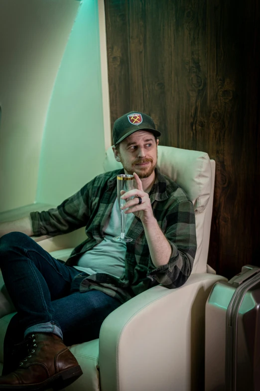 man sitting down and drinking a glass of beer