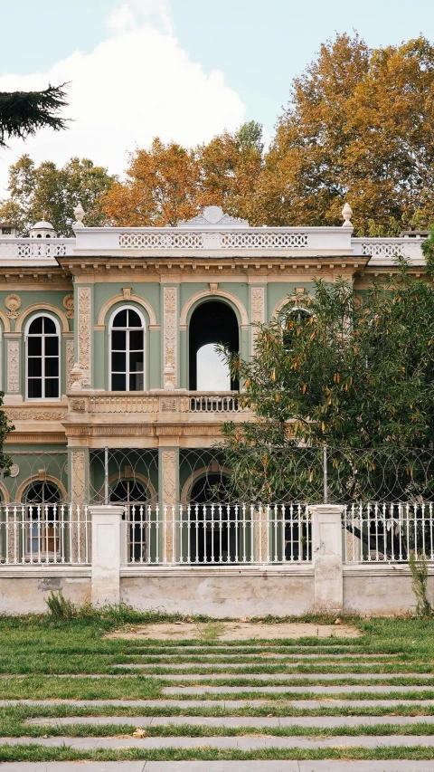 a stone stairway near a green building with a clock