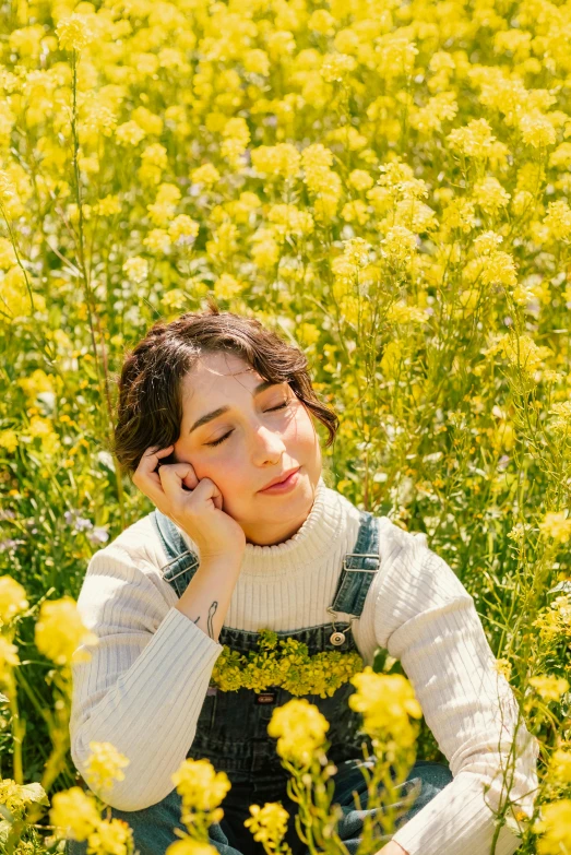 a woman laying down on the ground surrounded by tall grass