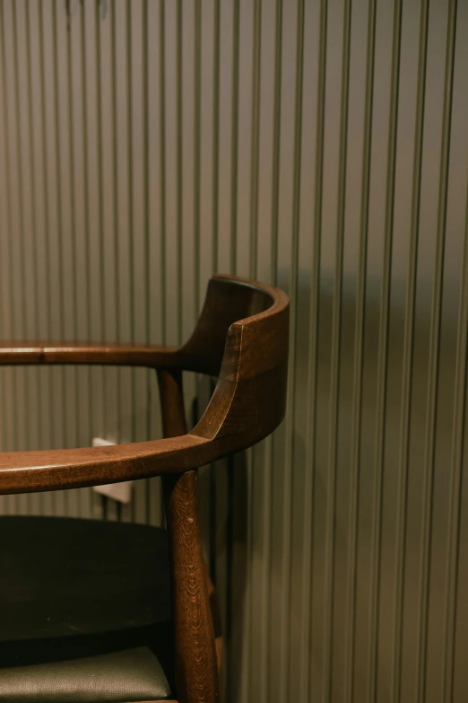 a wooden chair sitting next to a silver wall