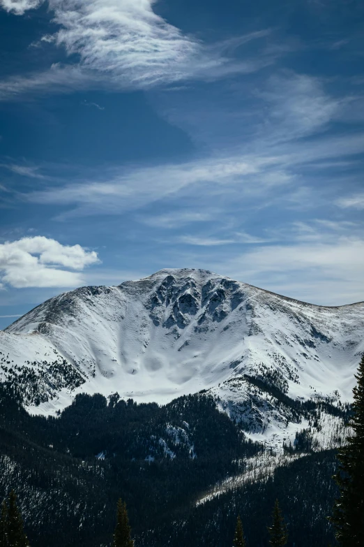 a beautiful snowy mountainside is pictured against a clear blue sky