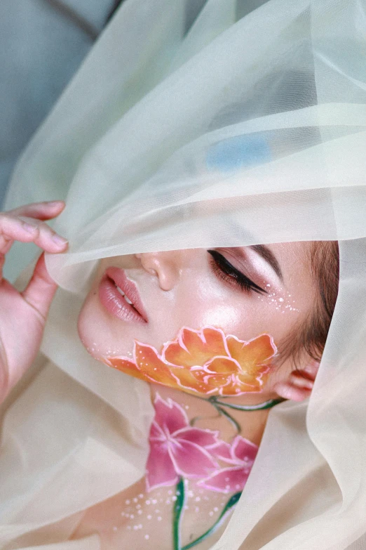 a woman with flowers painted on her face and veiled dress on