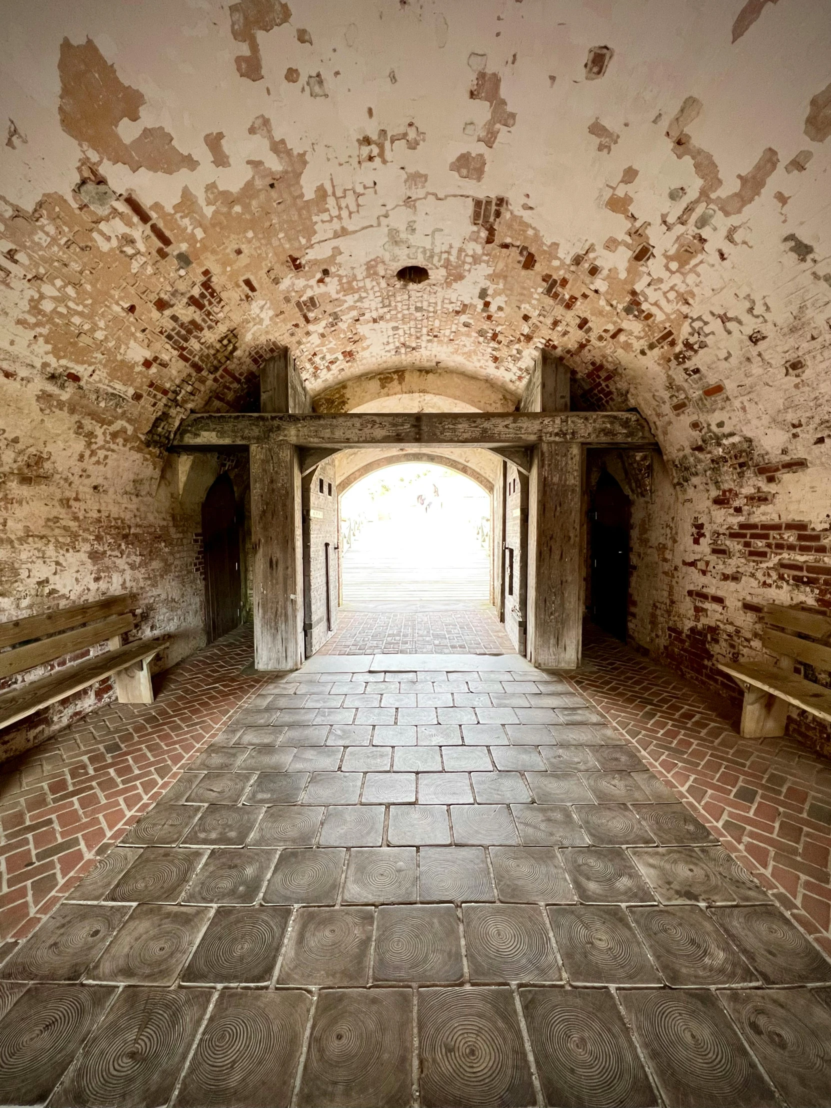 a very long brick walkway leading to a tunnel